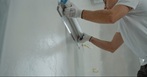 Mann trägt Innenputz auf eine Wand und glättet die Oberfläche bei Renovierungsarbeiten 