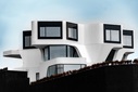 Einzigartiger moderner Hausbau mit markantem geometrischem Design und großen Fenstern
